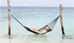 woman-wearing-bikini-sun-hat-relaxing-beach-hammock-asleep-32062734
